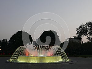 Night light view of circular waterjet fountain in Lima photo
