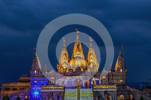 Night lighted image of Shree Swaminarayan temple with monsoon clouds background., Ambe Gaon, Pune .