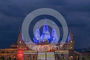 Night lighted image of Shree Swaminarayan temple with monsoon clouds background., Ambe Gaon, Pune . photo