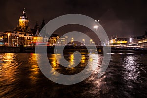 Night lighting reflections in Amsterdam channels from moving cruise boat. Blurred abstract photo as background.