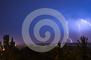 Night lightning storm over city in blue dramatic lighting