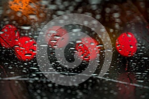 Night lights of urban traffic seen through the windshield in rainy weather. Abstract background. Concept of night city