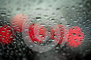 Night lights of urban traffic seen through the windshield in rainy weather. Abstract background. Concept of night city