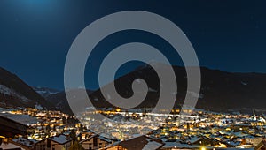 Night long exposure panorama of the city of Moena in italian dolomites in Val di Fassa region during winter time