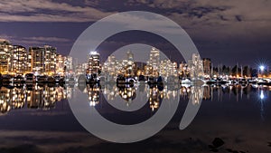 A night long exposure photo of marina inside Burrard Inlet of Vancouver Harbor with many docket boats