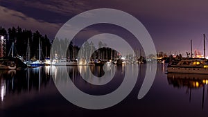 A night long exposure photo of yachts and boats docked in marina