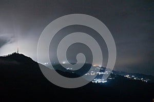 Night long exposure shot showing fog rolling over hills with village in distance showing prestine hills of darjeeling