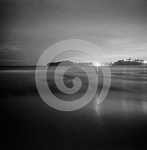 Night ocean long exposure with city lights in the distance Mona Vale New South Wales Australia square format monochrome film analo