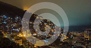 Night over Brazilian favelas on the hill with city downtown below, Rio De Janeiro, Brazil