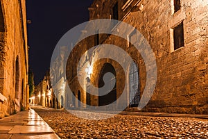 Night photo of ancient street of the Knights in Rhodes city on Rhodes island, Dodecanese, Greece. Stone walls and bright night