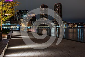 Night photo of the Boston waterfront with views over the bay and luminous skyscrapers. USA. Masachuses.