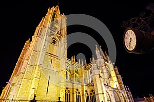 Night photo of the cathedral of Leon in Spain with urban clock in front of the building.