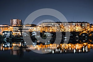 Night photo of the city over the river on a background of dark sky