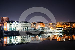 Night photo of the city over the river on a background of dark sky