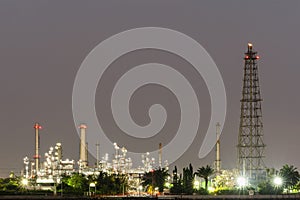 Night photo crude oil refinery plant and many chimney at coast of the river with colorful bright light from lamp at thailand