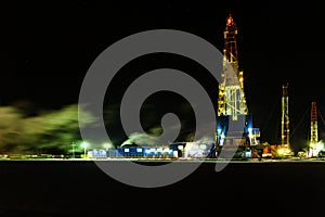 Night photo of grilling rig in oil field for drilled into subsurface