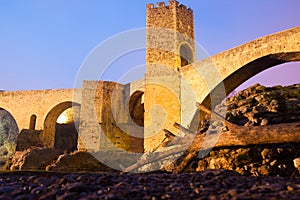 Night photo of Medieval bridge with city gate. Besalu, Catalonia