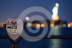 Night photo optical binoculars to view the Statue of Liberty blurry in the background