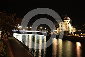 night photo of the ruins of the dome of hiroshima next to the river