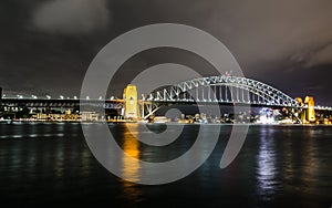 Night photography of Sydney Harbour Bridge in cloudy night.