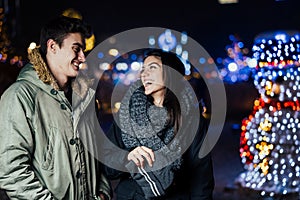 Night portrait of a happy couple smiling enjoying winter and snow aoutdoors.Winter joy.Positive emotions.Happiness