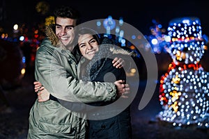 Night portrait of a happy couple smiling enjoying winter and snow aoutdoors.Winter joy.Positive emotions.Happiness