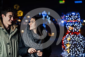 Night portrait of a happy couple smiling enjoying winter and snow aoutdoors.Winter joy.Positive emotions.Happiness