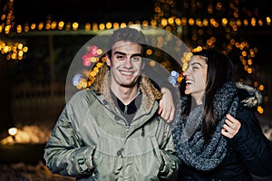 Night portrait of a happy couple smiling enjoying winter and snow aoutdoors.Winter joy.Positive emotions.Happiness