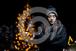 Night portrait of a sad woman feeling alone and depressed in winter.Winter depression and loneliness concept