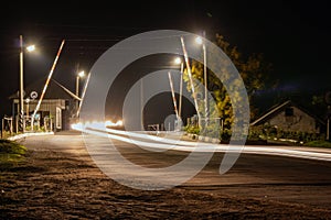 Night railway crossing with passing cars