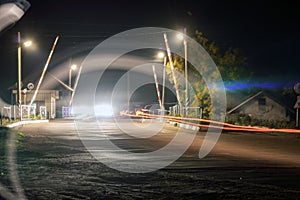 Night railway crossing with passing cars