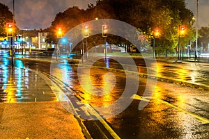 Night rain view yellow traffic lights at UK roundabout