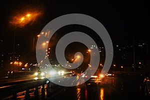 night rainy city with luminous lanterns on a wet road.