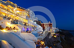 Night restaurant with tourists from Fira Santorini, the famous European resort, Greece photo