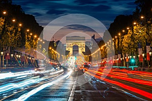 Night scence illuminations traffic street of the Impressive Arc de Triomphe Paris along the famous tree lined Avenue des Champs-