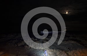 Night scene on the beach. Illuminated in the foreground. And a lunar path in the sea reflected from the moon. Top view.