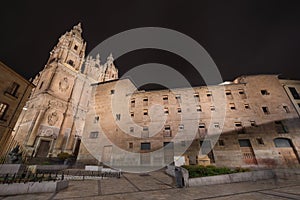 Night scene of Clerecia church and casa de las conchas at night, famous landmarks in Salamanca, Spain.