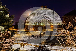 Night scene of the Desert Dome, with the moon barely visible on the side, at Henry Doorly Zoo Omaha Nebraska.