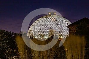 Night scene of the Desert Dome, with the moon barely visible through the top, at Henry Doorly Zoo Omaha Nebraska.