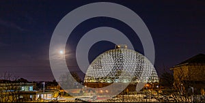 Night scene of the Desert Dome, with the moon riding on the side, at Henry Doorly Zoo Omaha Nebraska.