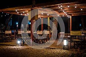 Night scene of an elegant outdoor bar illuminated by small hanging bulbs