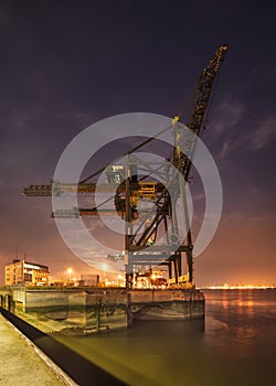 Night scene with gigantic crane on illuminated container terminal