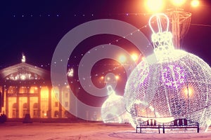 Night scene with illuminated Christmas balls and theater