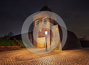 Night scene with illuminated gatehouse in fortified city