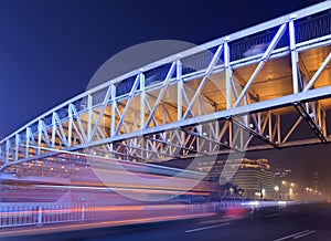 Night scene with illuminated pedestrian bridge and traffic in motion blur, Beijing, China