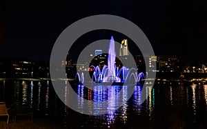 Night scene of the lake and fountain with light reflections in the water at the Heartland of America Park Omaha Nebraska USA.