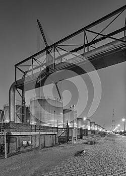 Night scene with large silo and pipeline overpass