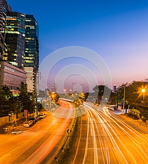 night scene of modern city. Building and light trail on road wit