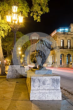 Night scene in Old Havana with a famous bronze lion considered a symbol of the city