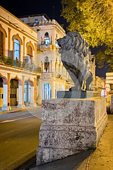 Night scene in Old Havana with a famous bronze lion considered a symbol of the city